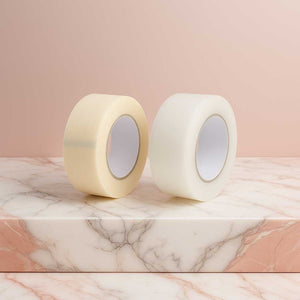 wee rollen lash tape op marmeren oppervlak met roze achtergrond -wimperextensions tape.