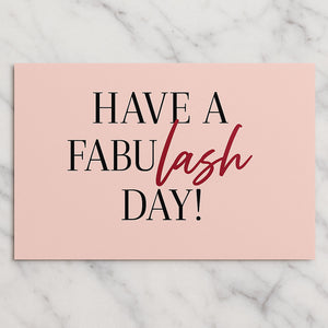 Een roze ansichtkaart met de tekst 'HAVE A FABULASH DAY!' in zwarte letters van Luxury Lashes.