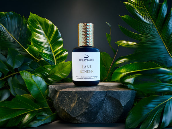 Luxury Lashes Lash Bonder flesje op stenen standaard met groene bladeren op de achtergrond - retentiebooster voor wimperextensions.